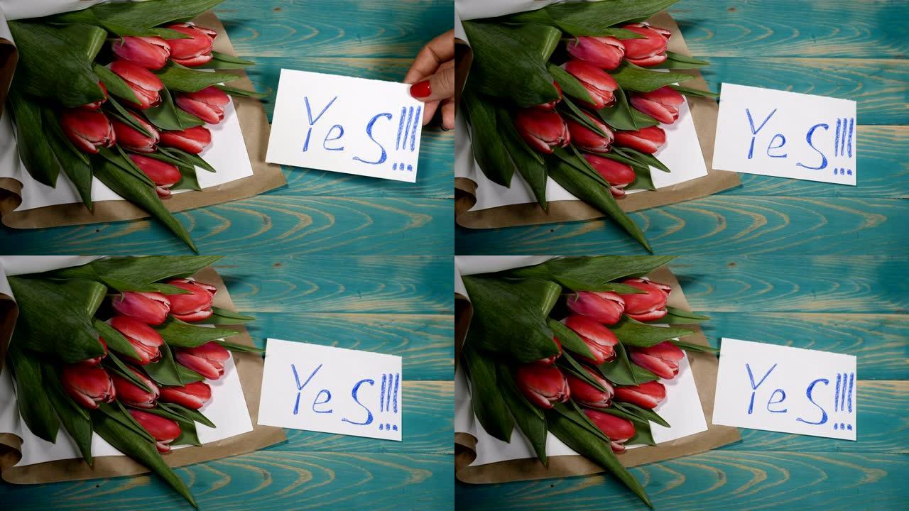 木桌上的Yes消息注释和郁金香花束的俯视图。夫妻关系概念。情人节。4 k拍摄
