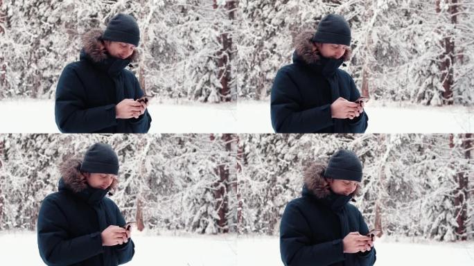 年轻快乐的帅哥在户外用手机聊天，冬季森林男模