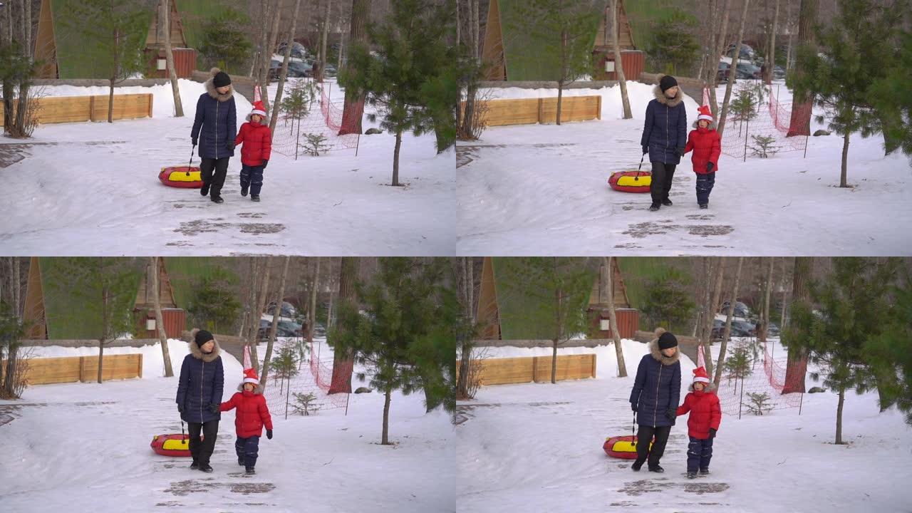 一名年轻女子和她的小儿子在山区度假活动公园的油管上玩得很开心。寒假概念
