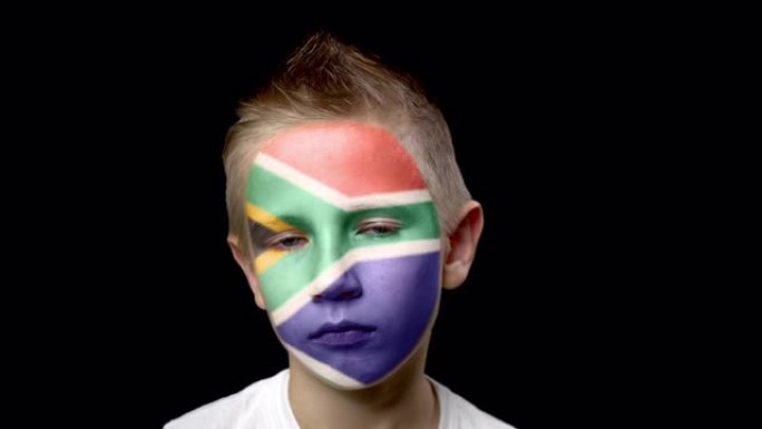 南非足球队的悲伤球迷。脸上涂着民族色彩的孩子。