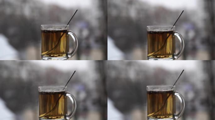 白雪皑皑的城市景观背景上的一杯热茶