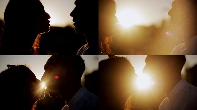 浪漫的年轻情侣剪影在日落时接吻，太阳照在地平线上。