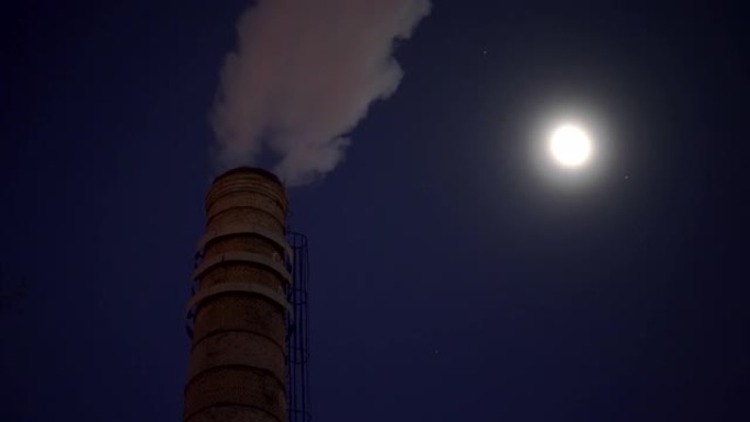 在月光下的夜晚，工业烟堆向空气中喷出蒸汽