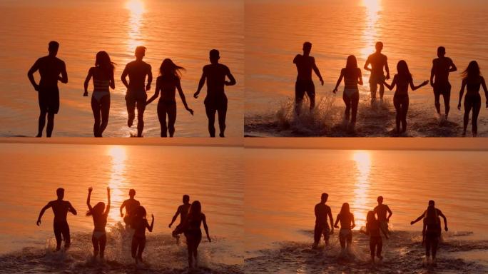 年轻的朋友们在美丽的夕阳下跑进水里。慢动作