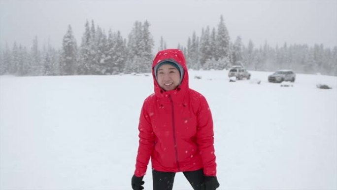 亚洲女子在白雪皑皑的公园跳跃