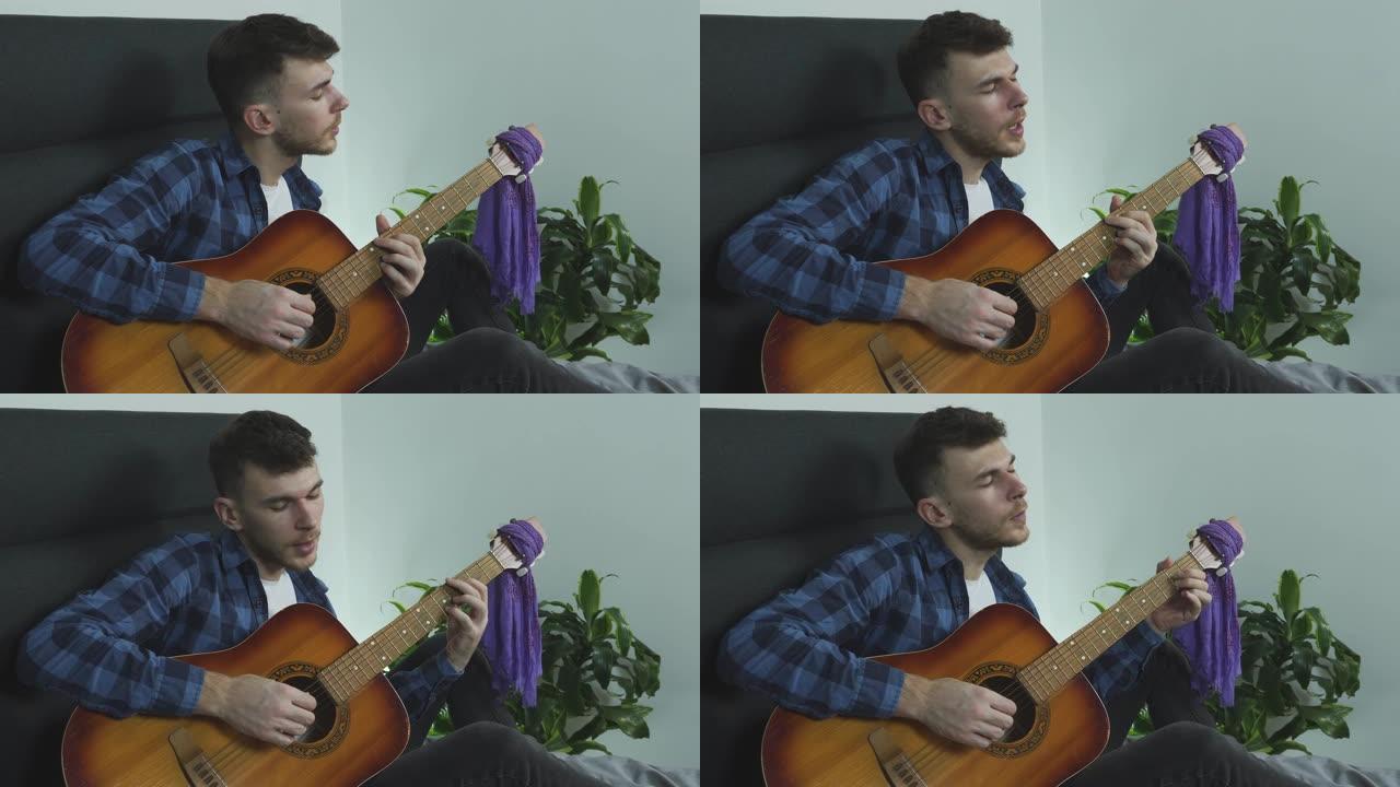 吉他音乐家在原声吉他上演奏民谣歌曲，并在床上在家唱歌。