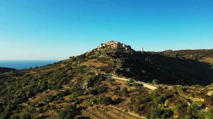 在法国科西嘉岛一个美丽的晴天，Sant'Antonino村和通往该村庄的道路