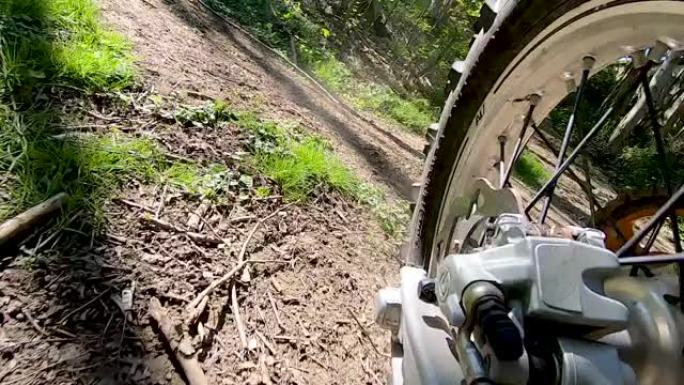摩托车后轮和发动机的特写在森林中的越野小径中加速