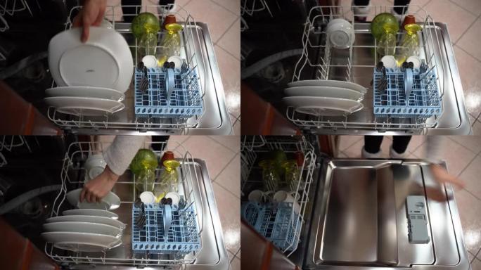 家庭主妇把脏盘子放在洗衣机的篮子里，然后关上。女人用脏餐具灌装洗衣机，家庭主妇的日常厨房工作