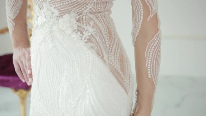 双手触摸美丽的白色婚纱的腰部并抚摸线条