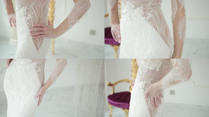 双手触摸美丽的白色婚纱的腰部并抚摸线条
