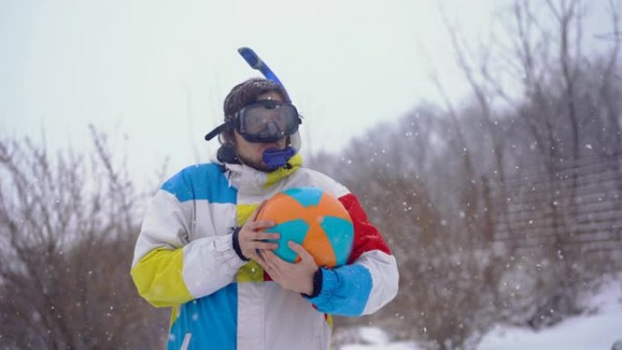 穿着带充气球的潜水面具的滑稽男子站在降雪下。迷失在时间里