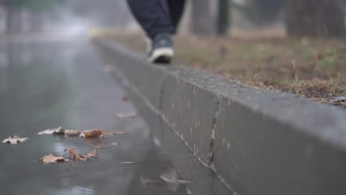 秋天下雨后的小巷在秋天，人们的脚沿着人行道行走
