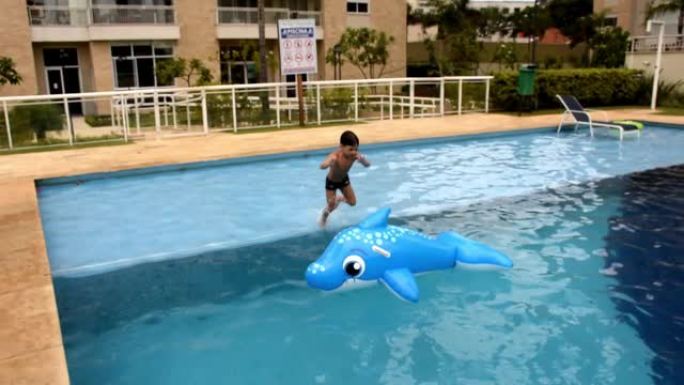 6岁的孩子在游泳池里玩海豚彩车。