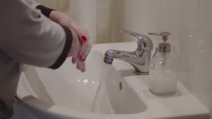 女人在浴室用水，肥皂和泡沫洗手