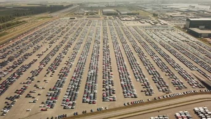 在巨大的停车场上等待运输的许多新车和场合汽车，空中