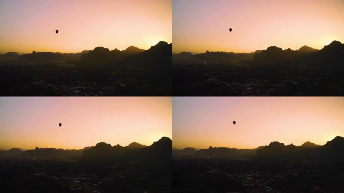 在老挝万旺的山上，热气球乘坐充满活力的日出
