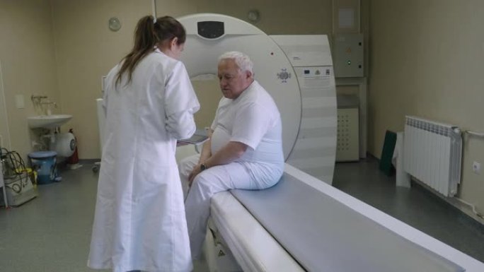 放射科医生为工作准备医疗扫描仪。与患者交谈并帮助他为手术做准备。