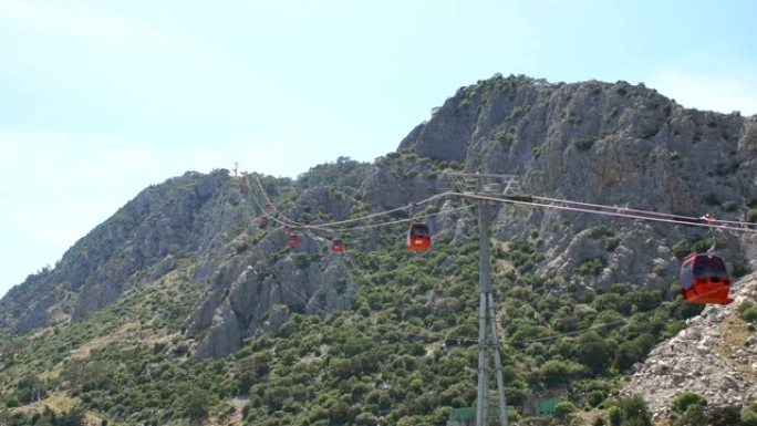 高山背景上有红色拖车的缆车。土耳其安塔利亚。
