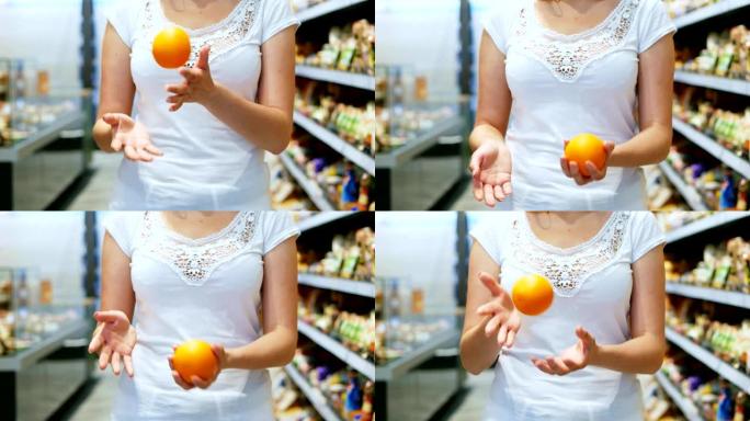 女人的手在超市里慢动作地抛出五颜六色的橙色