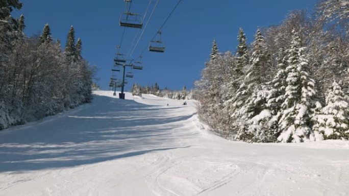 滑雪缆车上滑雪者的风景，雪山覆盖着滑雪坡道