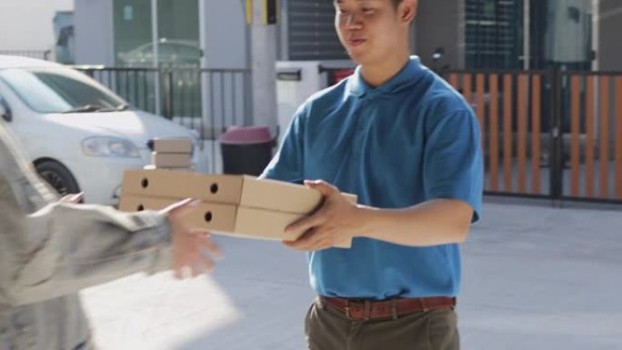 在线订购食品和送货服务理念。穿着制服或快递的送货员在家门口向年轻女性顾客送披萨。4k镜头分辨率。