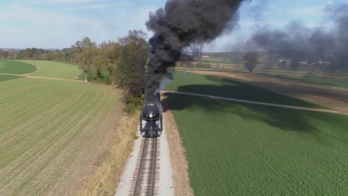 鸟瞰图的古董修复蒸汽机在农田吹黑烟与一个头的观点