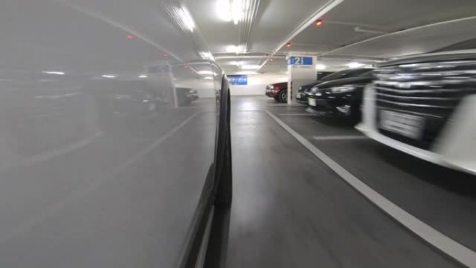 Pov开车穿过城市的地下停车场，实时。地下停车场可能在购物中心