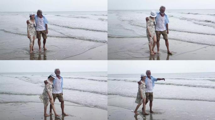 活跃的老年人夫妇在海滩上散步和微笑
