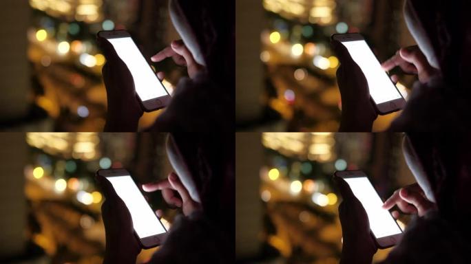女性晚上使用智能手机的特写镜头