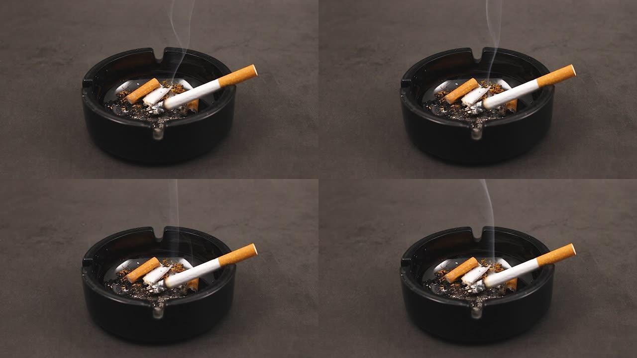 黑色烟灰缸中的香烟，烟头冒烟