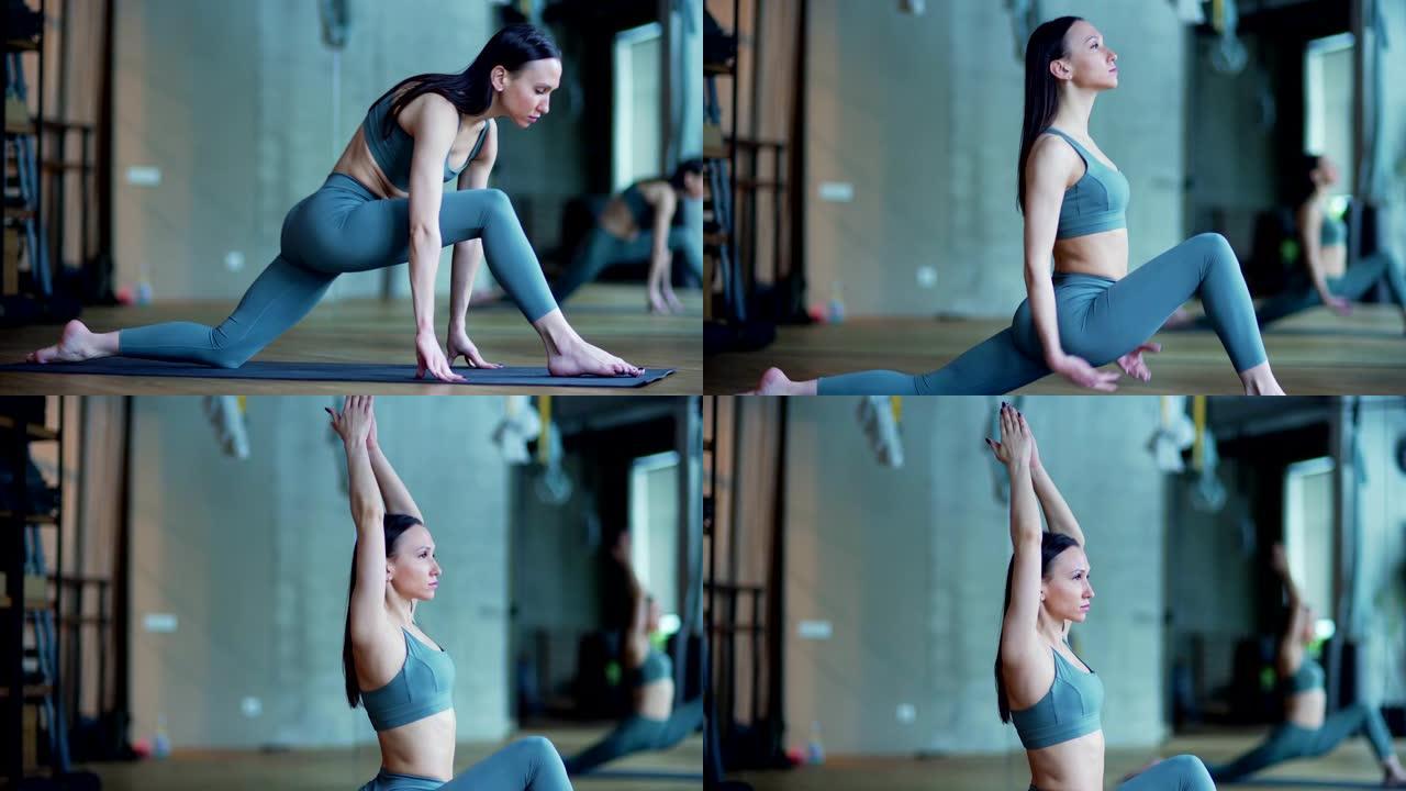年轻女瑜伽教练在瑜伽工作室练习时在垫子上表演战士瑜伽姿势的侧视图