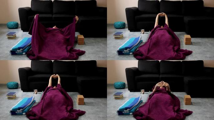 女人躺在客厅地板上伸展身体，上面铺着紫色毯子