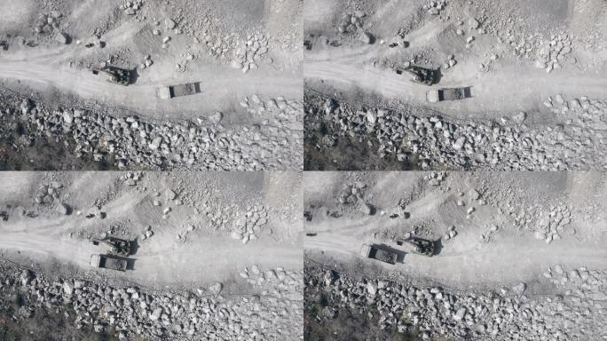 自卸车的鸟瞰图在露天矿山内的土路上运送岩石