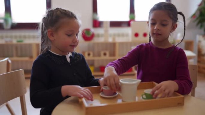 两个可爱的女孩在幼儿园举行茶会