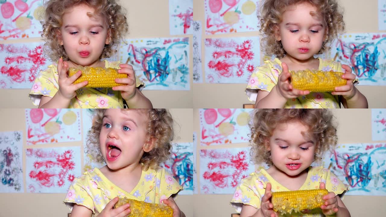 可爱的小女孩在玉米棒上吃煮玉米