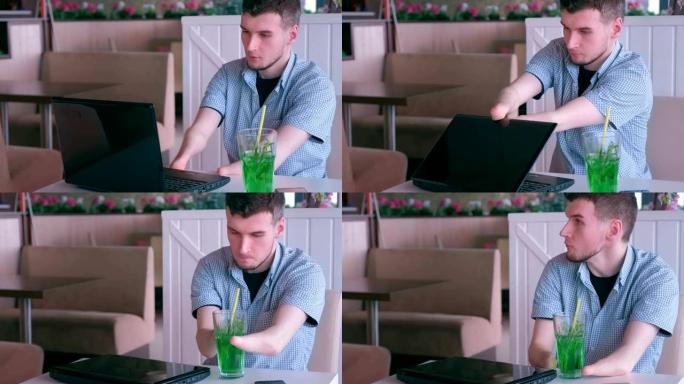 一个双手被截肢的残疾人在咖啡馆用笔记本电脑工作。
