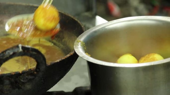 用钢包从热罗望子咖喱中提取或过滤印度鸡蛋和