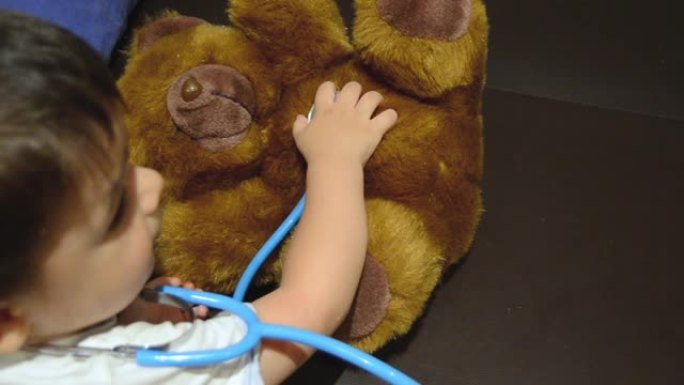 蹒跚学步的孩子在他的泰迪熊上使用听诊器
