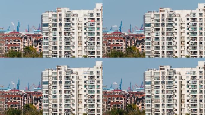 阳光明媚的下午，带有烟囱和港口背景的上海公寓楼的延时视频，4k镜头。