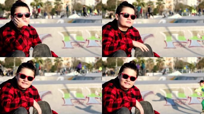 十几岁的男孩在滑板公园看着相机