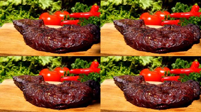 蔬菜背景下的木板上准备的美味肉排