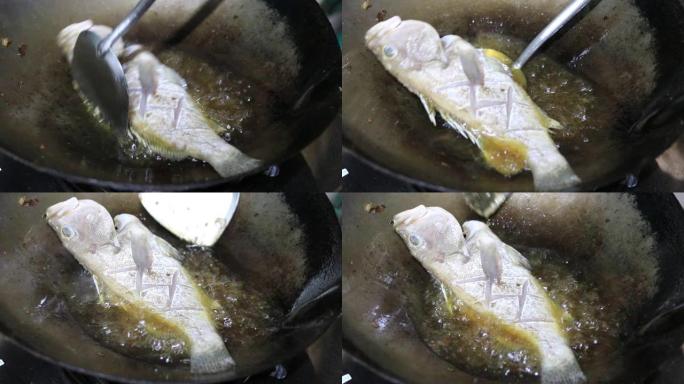 在锅里用热油炸石斑鱼。泰式食物。烹饪概念。食物，油炸食物