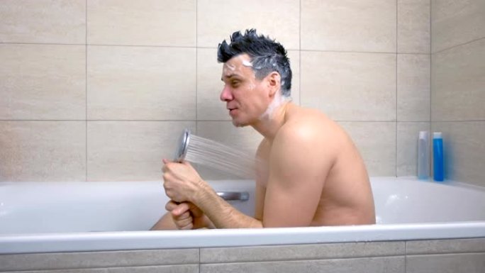 用莫霍克洗发水洗头的快乐男人在浴缸里洗澡时唱歌。