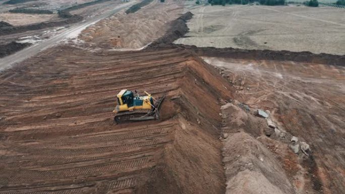 推土机在建筑公寓楼上挖掘沙石采石场城市睡眠区从履带挖掘机上的顶部无人机视图控制操作员为公寓楼做准备