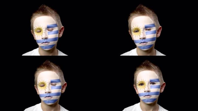 乌拉圭足球队的悲伤球迷。脸上涂着民族色彩的孩子。