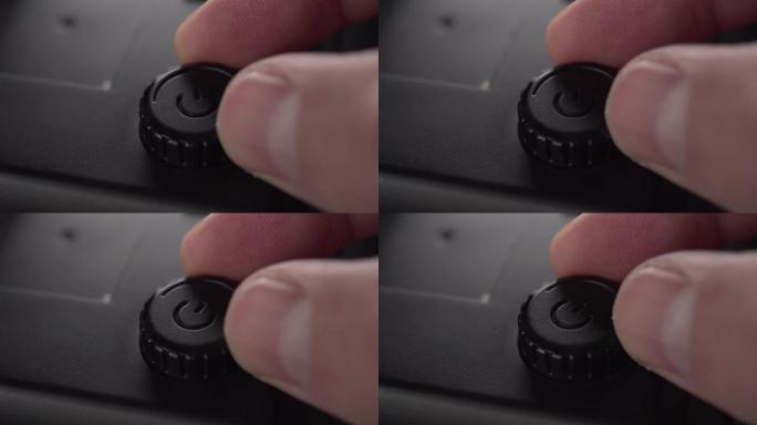 带有塑料外壳的黑色启动按钮和电源调节装置扭曲手指