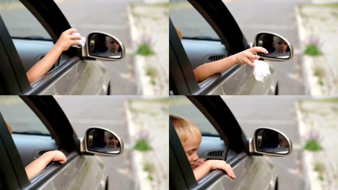 一个粗鲁男孩的特写镜头把垃圾从车窗扔到路上。