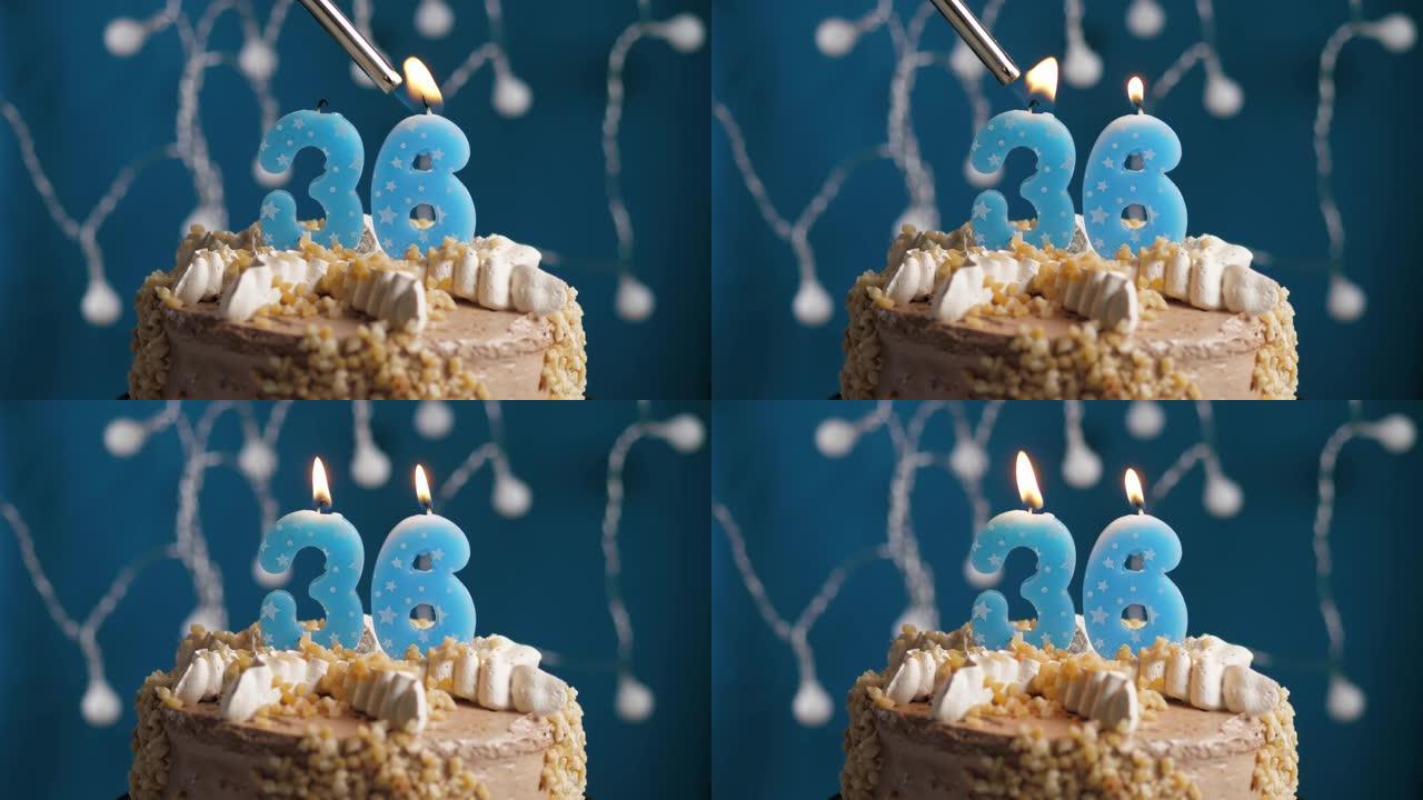 蓝色背景上有36号蜡烛的生日蛋糕。蜡烛着火了。慢动作和特写视图