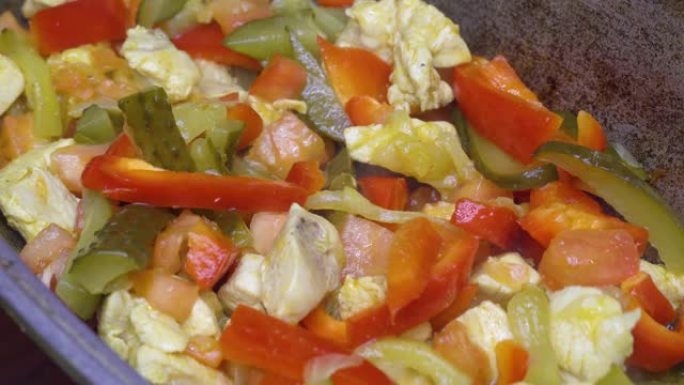 炒洋葱和鸡块在平底锅中炸，红辣椒，切碎的番茄，腌黄瓜。